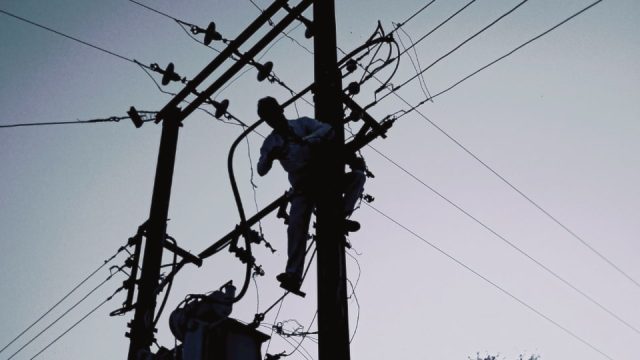Man working on utility pole wires