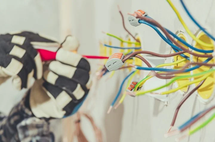 Electrcian contractor preparing wires for plug installation.