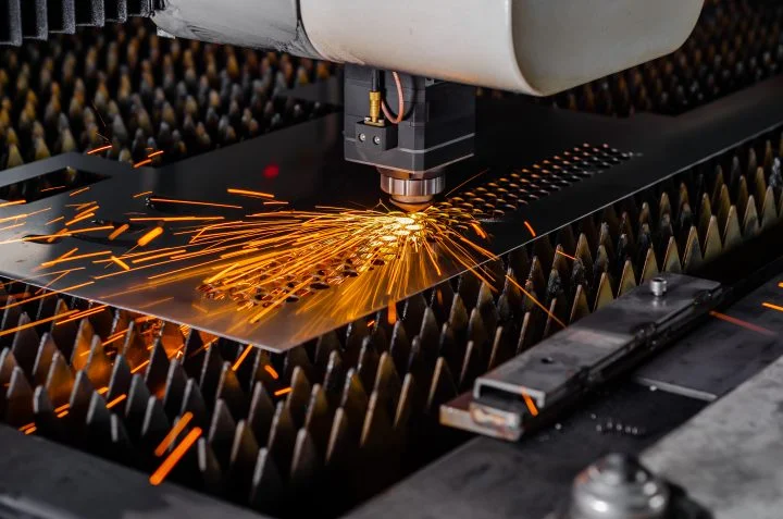 Laser machine cuts a metal sheet.