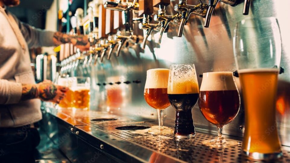 several beers on tap being poured.