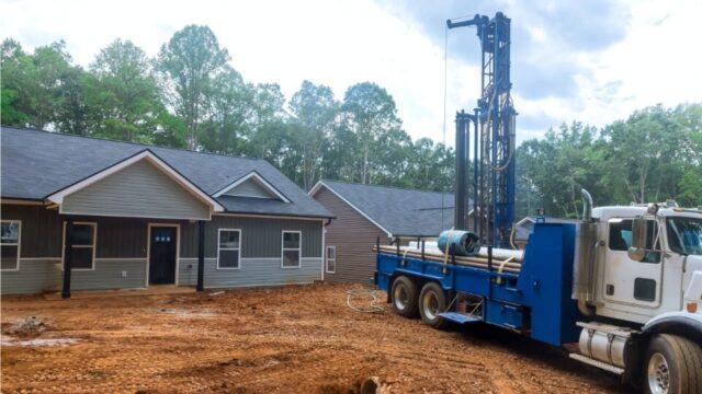 Well drilling truck in front of a new home being built.