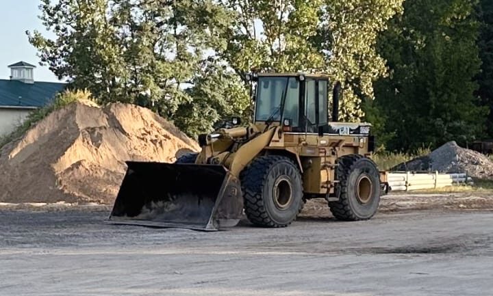 Front Loader in front of a dirt pile.