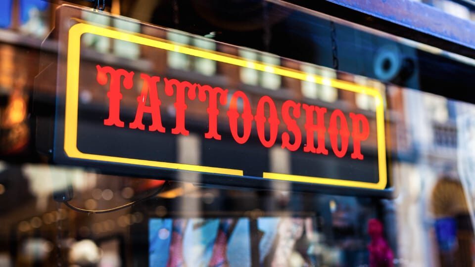 lighted Tattoo Shop sign in a window.