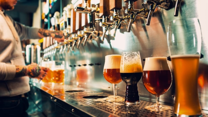 a bartender pouring multiple pints of beer.